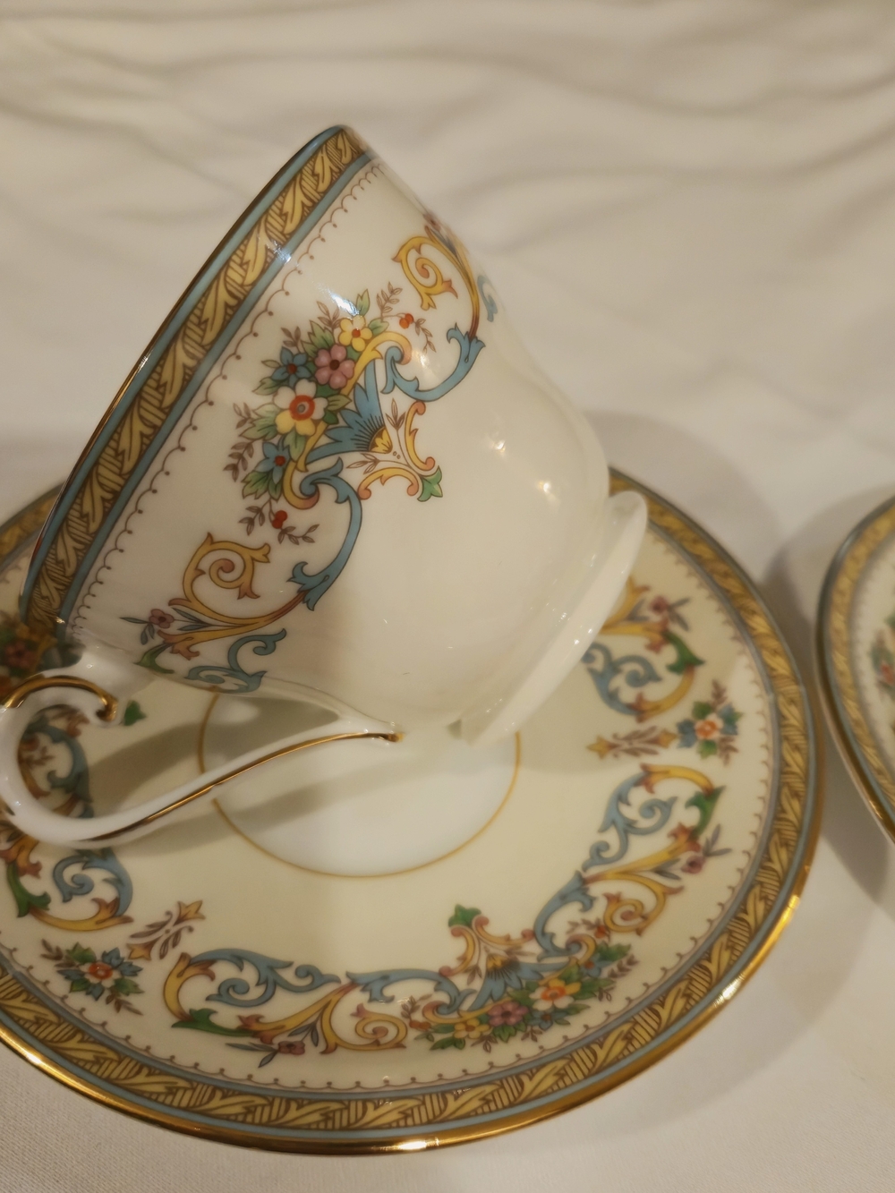 White Porcelain Teacup and Saucer Set with Blue and Gold Floral Motif